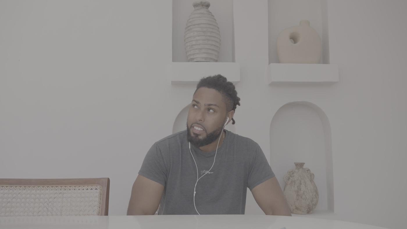 Corey at the table, to camera