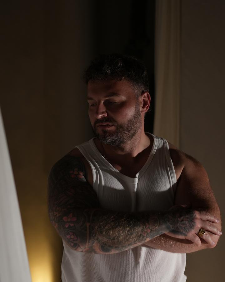 Joshua at the villa, arms crossed